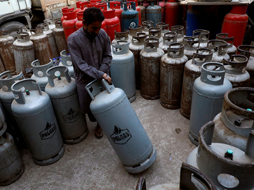 A worker moves a liquid petroleum gas (LPG) cylinder at a workshop in Karachi (File Photo/Reuters)